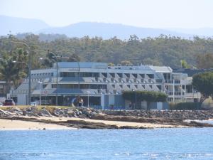 a building on the beach next to the water at The Esplanade Motel in Batemans Bay