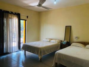 a bedroom with two beds and a window with a view at Habitaciones Chalo in Garita