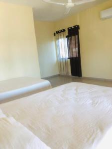 - un lit blanc dans une chambre avec fenêtre dans l'établissement Habitaciones Chalo, à Garita