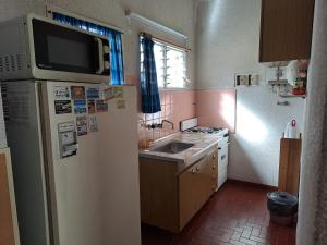 una pequeña cocina con nevera y fregadero en Barracuda 5 en Santa Teresita