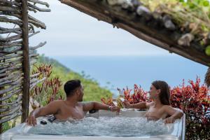 un homme et une femme assis dans une baignoire dans l'établissement MATHIS Lodge Amed, à Amed