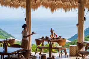 une femme debout devant une table dans un restaurant dans l'établissement MATHIS Lodge Amed, à Amed 64 autres photos