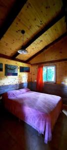 1 dormitorio con 1 cama grande en una habitación de madera en Bosque Nativo en Lago Puelo