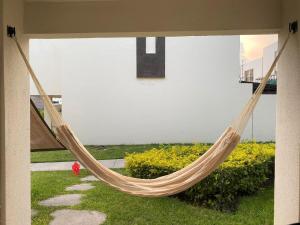 eine Hängematte, die von einem Gebäude im Hof hängt in der Unterkunft Casa Bonita II, pie alberca, AirAc in Xochitepec