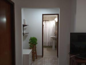 a hallway with a bathroom with a sink and a television at FREEDOM Joa in Río Gallegos