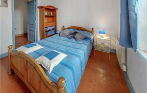 1 dormitorio con cama de madera y edredón azul en Nice Apartment In Fox Amphoux With Wifi, en Fox-Amphoux