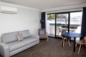 sala de estar con sofá y mesa en The Esplanade Motel, en Batemans Bay