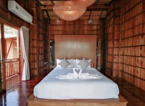 a bedroom with a bed with a bow on it at Pan's farm แบ่งปันฟาร์ม in Ban San Phaya Loei Luang