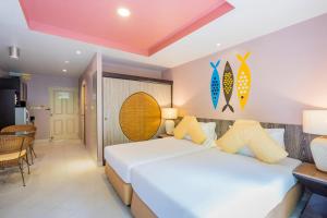 1 dormitorio con 2 camas, mesa y sillas en Bella Villa Prima, en Pattaya central