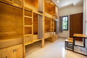 Pokój z drewnianymi ścianami i łóżkami piętrowymi w obiekcie K Hostel Seminyak w mieście Seminyak
