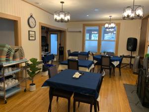 a restaurant with blue tables and chairs and a clock at Auberge Clos-Joli in Morin Heights