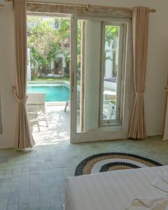 ジンバランにあるSurga Tropical Suitesのベッドルーム1室(スイミングプールに面したドア付)