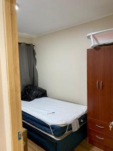 a small bedroom with a bed and a closet at Cabaña Loncoche, villarrica in Loncoche