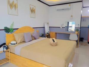 een slaapkamer met een bed met een telefoon erop bij Baan Tipsukon in Ko Larn