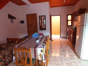 cocina y comedor con mesa y nevera en Madre Selva Iguazu en Puerto Iguazú