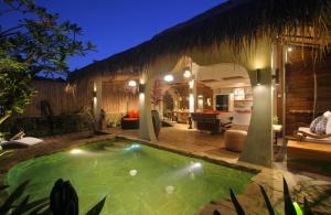 una piscina en el patio trasero de una villa por la noche en Villa Tatu by Optimum Bali Villas, en Canggu