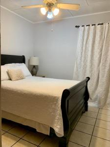 a bedroom with a bed and a ceiling fan at Room near Airport/ Cerca del Aeropuerto in Santiago Este