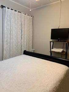 a bedroom with a bed and a flat screen tv at Room near Airport/ Cerca del Aeropuerto in Santiago Este