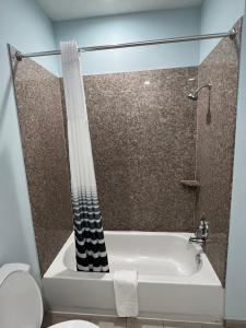 y baño con ducha, bañera y aseo. en Americas Best Value Inn Sulphur, en Sulphur