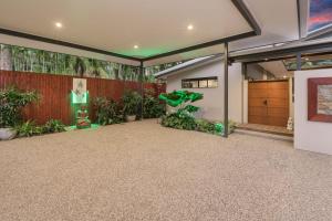 a house with a garage with plants and a fence at Villa Thirty One - Balinese inspired Escape in Cairns