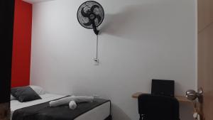 1 dormitorio con 1 cama y ventilador en la pared en PRIMAVERA LIVING, en Medellín