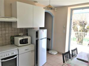a kitchen with a white refrigerator and a microwave at Maison Ruoms, 3 pièces, 4 personnes - FR-1-697-2 in Ruoms