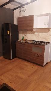 a kitchen with a refrigerator and a stove top oven at PRIMAVERA LIVING in Medellín +50 photos