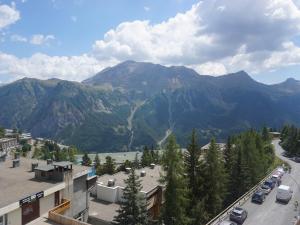 T3 60m² 6/7 pers à 50m des pistes, animaux acceptés, linge inclus hiver - FR-1-636-222 في أورسيير: اطلاله على جبل فيه سيارات متوقفه على طريق +5 صور