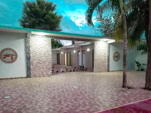 a house with a courtyard with a palm tree at Hotel Blue Turtle in Bacalar