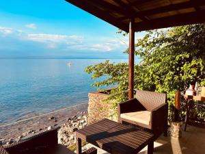 a chair sitting on a porch overlooking the ocean at Villa Milagros Dive Inn Anilao in Bagalañgit