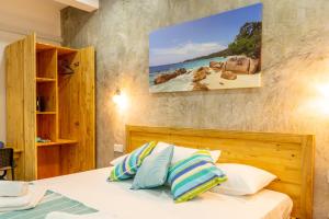 um quarto com uma cama e um quadro na parede em VincVilla em Praslin