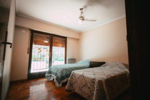 1 dormitorio con 2 camas y ventana en Casa Quinta Seccion en Mendoza