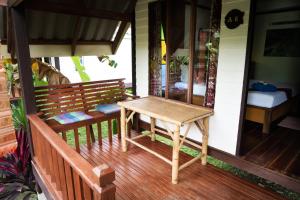 a wooden bench on the porch of a house at Lanta Andaleaf Bungalow - SHA Extra Plus in Ko Lanta