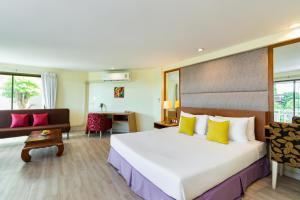 Habitación de hotel con cama grande y sofá en Bella Villa Metro, en Norte de Pattaya