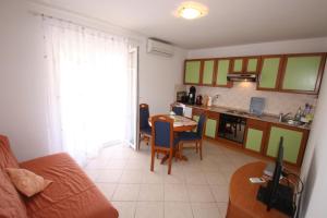 a living room with a table and a kitchen at Apartments Rose in Poreč
