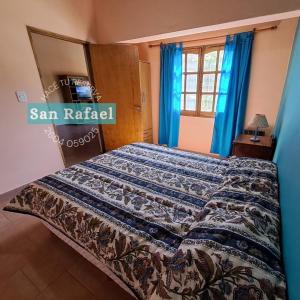 1 dormitorio con 1 cama con edredón azul en Departamento Céntrico en San Rafael