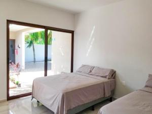 een slaapkamer met een bed en een glazen schuifdeur bij Hotel Blue Turtle in Bacalar