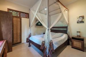 a bedroom with a bed with a canopy at White Lotus Oasis in Ubud