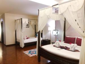 1 dormitorio con 2 camas con cortinas blancas en Vdara Pool Resort Spa Chiang Mai en Chiang Mai