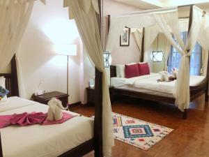 1 dormitorio con 2 camas, cortinas y espejo en Vdara Pool Resort Spa Chiang Mai en Chiang Mai