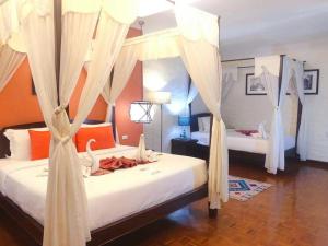 1 dormitorio con 2 camas con mosquiteras en Vdara Pool Resort Spa Chiang Mai en Chiang Mai