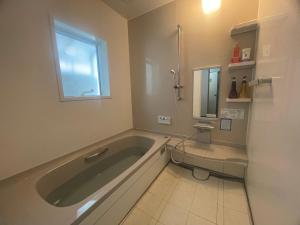 a bathroom with a large tub and a toilet at ZU-THONES HAKUBA ANNEX in Yotsuya