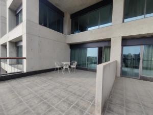 a balcony of a building with a table and chairs at Terrazzo Suits in Ahmedabad