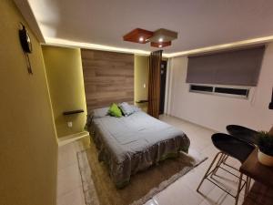 a bedroom with a bed and a yellow wall at Departamentos fresno! Una excelente opción in Toluca