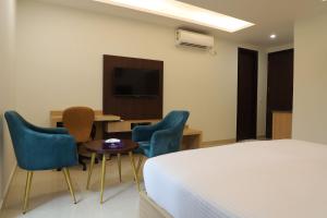Habitación de hotel con cama, sillas y mesa en Hotel Gurugram, en Gurgaon