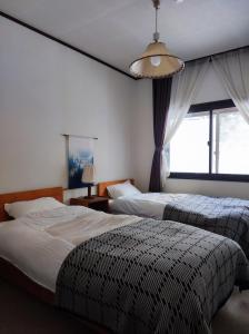 Un pat sau paturi într-o cameră la GUEST HOUSE ZU-THONES HAKUBA