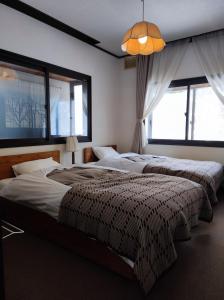 Un pat sau paturi într-o cameră la GUEST HOUSE ZU-THONES HAKUBA