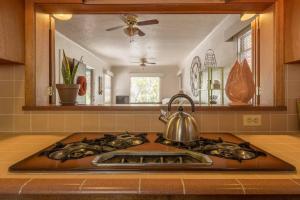 a kitchen with a stove with a tea kettle on it at Colonial Cottage Getaway in Atascadero