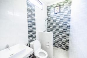 サヌールにあるGria Umasari Sanurのトイレと洗面台を備えた白いバスルーム