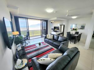 sala de estar con sofá y sala de estar con balcón. en Cairns Luxury Seaview Apartment en Cairns
